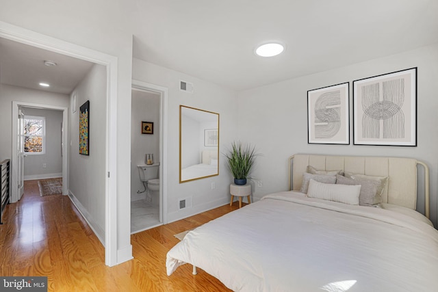 bedroom featuring hardwood / wood-style floors and connected bathroom