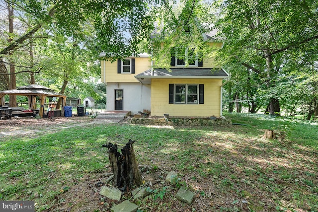 rear view of house with a gazebo and a lawn