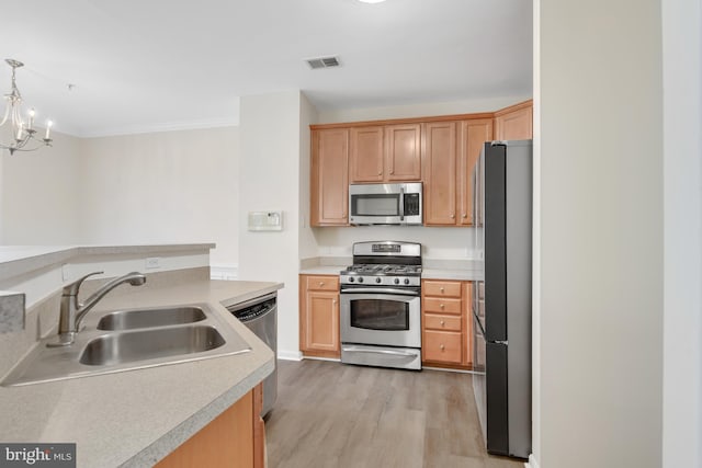 kitchen with sink, light hardwood / wood-style flooring, appliances with stainless steel finishes, decorative light fixtures, and a chandelier