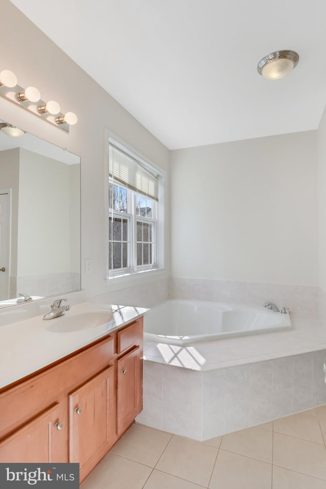 bathroom featuring tile patterned floors, vanity, and tiled tub