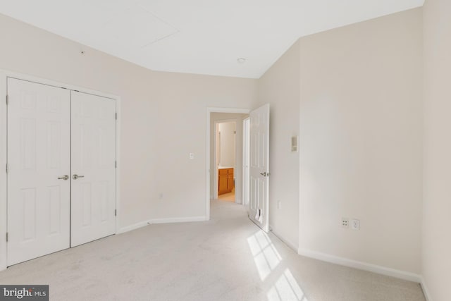 unfurnished bedroom featuring light carpet and a closet