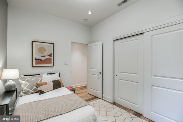 bedroom with light wood-type flooring and a closet