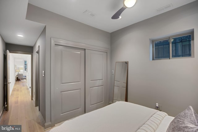 bedroom with ceiling fan, a closet, and light wood-type flooring