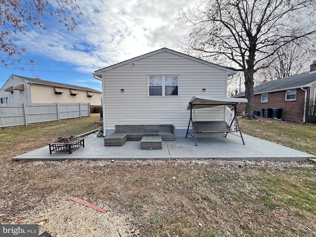 back of property featuring a patio area and an outdoor living space with a fire pit