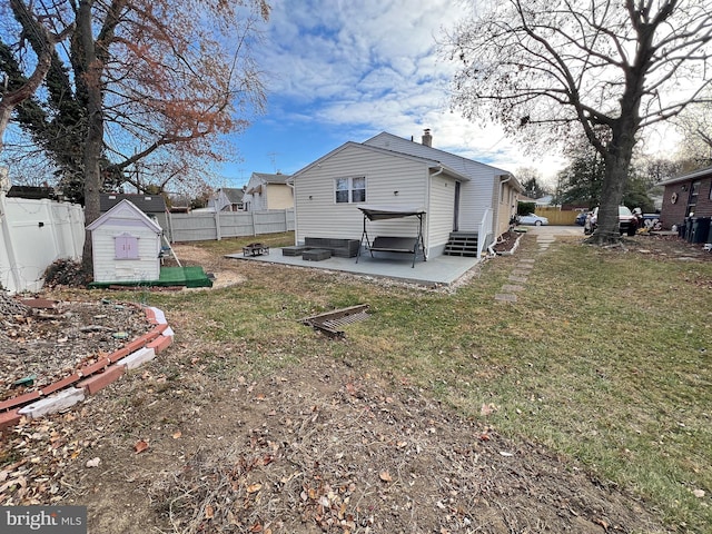 back of house featuring a lawn and a patio area