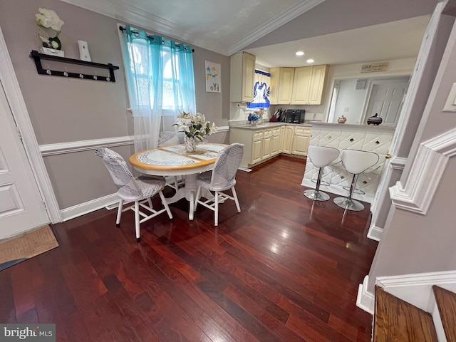 dining space featuring dark hardwood / wood-style flooring, vaulted ceiling, and ornamental molding