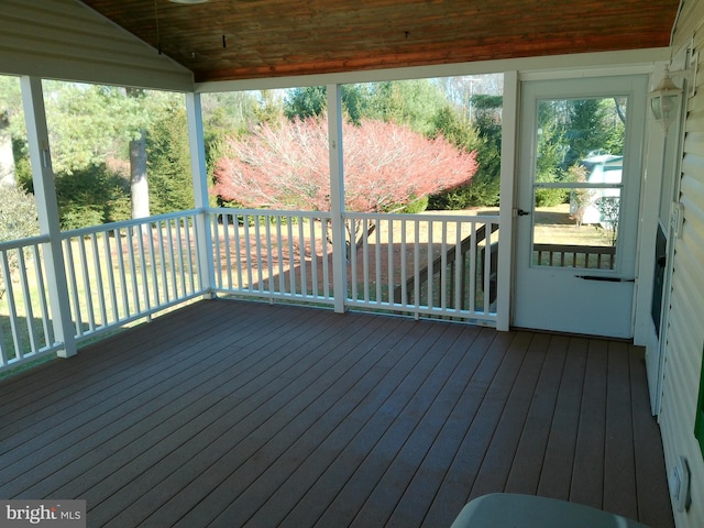 unfurnished sunroom featuring vaulted ceiling