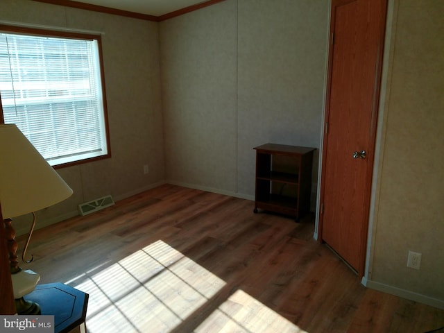 spare room featuring hardwood / wood-style floors and ornamental molding