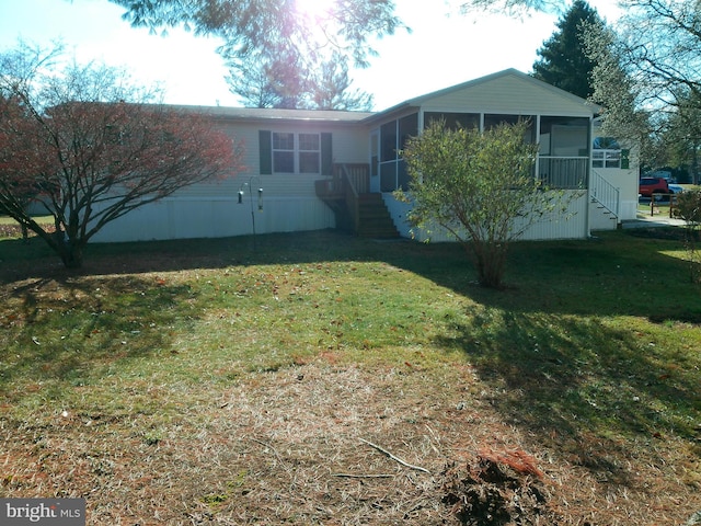 back of property with a sunroom and a yard