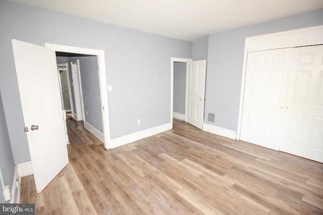 unfurnished bedroom featuring light wood-type flooring and a closet