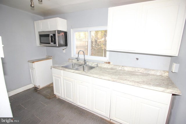 kitchen featuring white cabinets and sink