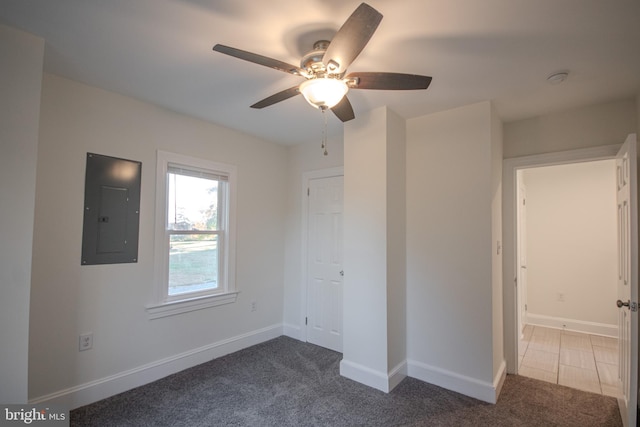 unfurnished bedroom featuring electric panel, ceiling fan, and dark carpet