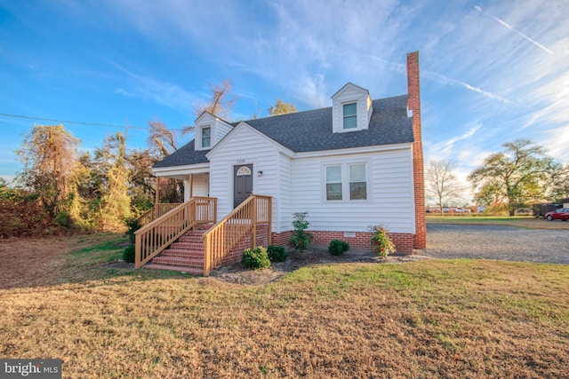 cape cod home with a front lawn