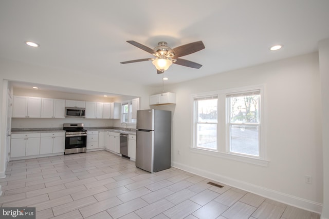 kitchen featuring ceiling fan, white cabinetry, and appliances with stainless steel finishes