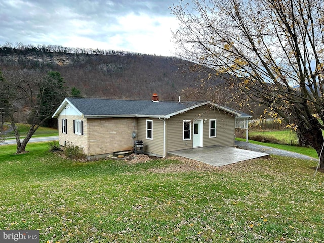 back of house featuring a patio area and a yard