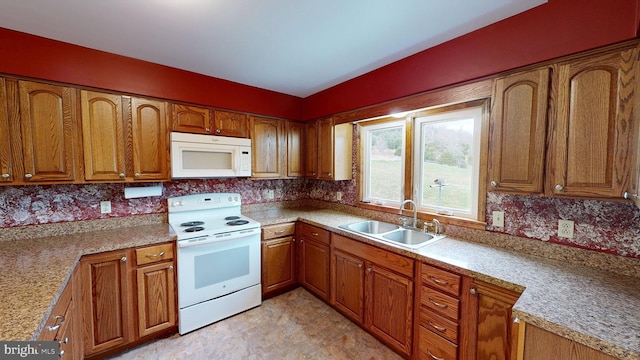 kitchen featuring backsplash, sink, and white appliances