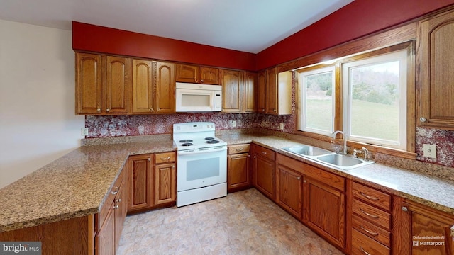 kitchen featuring backsplash, light stone counters, white appliances, and sink