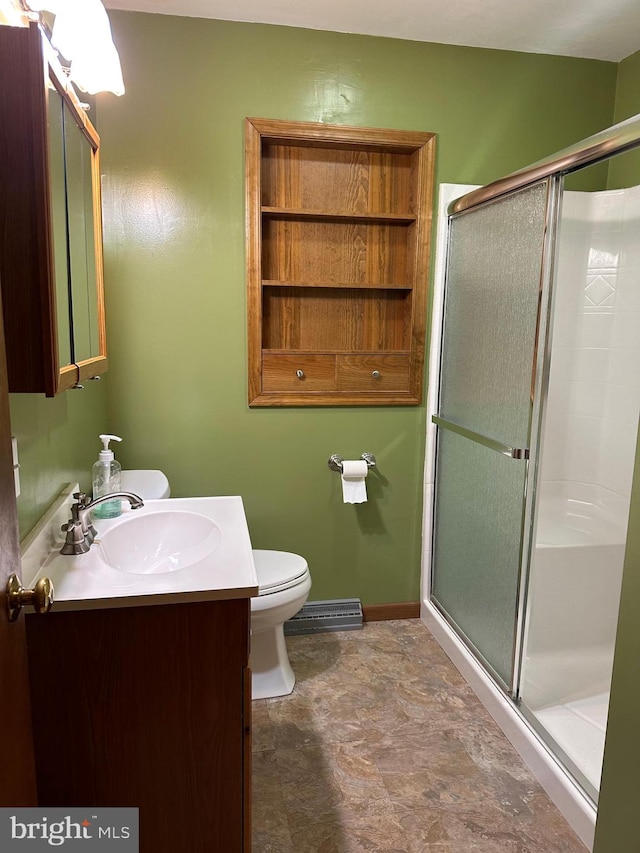 bathroom featuring vanity, toilet, and a shower with door