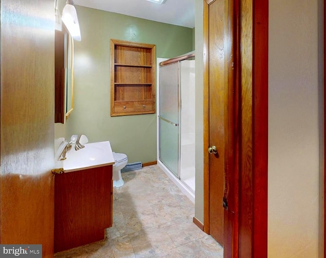 bathroom with vanity, toilet, and a shower with shower door