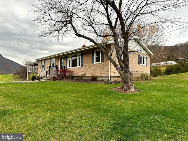 view of front of property with a mountain view and a front yard