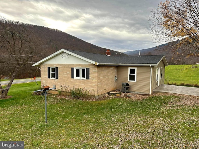 exterior space featuring a mountain view, a yard, and a patio