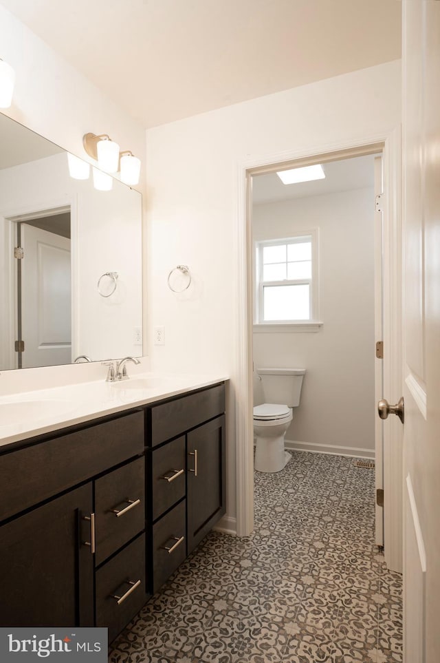 1002 Jacks Pl, Harrisburg, PA 17112 - bathroom featuring baseboards, toilet, vanity, and tile patterned floors