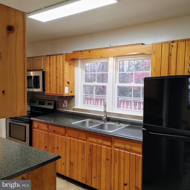 kitchen with backsplash, sink, and appliances with stainless steel finishes