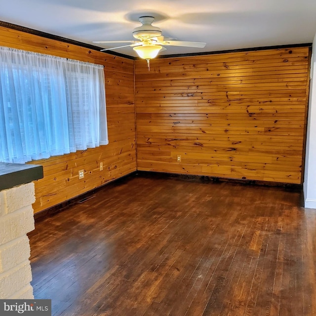 unfurnished room with wooden walls, dark hardwood / wood-style flooring, and ceiling fan