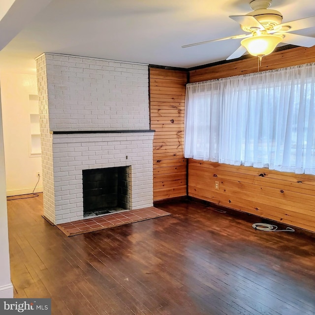 unfurnished living room featuring dark hardwood / wood-style flooring, ceiling fan, and wood walls