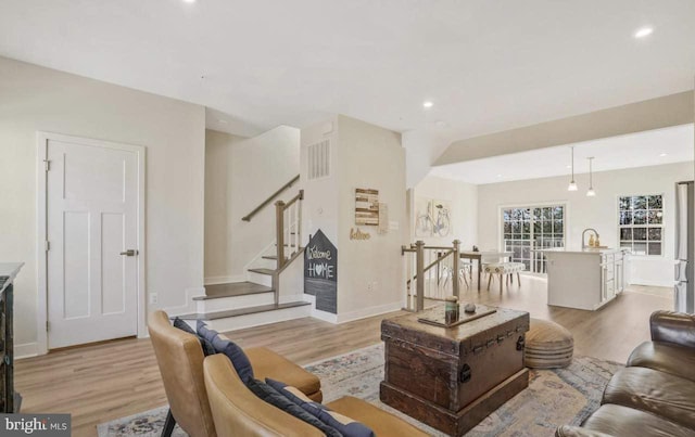 living room with sink and light hardwood / wood-style floors