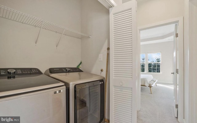 laundry area featuring light carpet and washing machine and clothes dryer