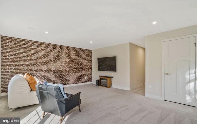 living area with light carpet and brick wall