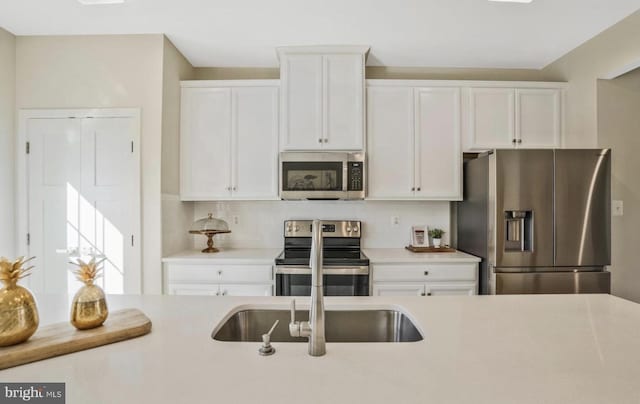 kitchen with backsplash, stainless steel appliances, and white cabinetry