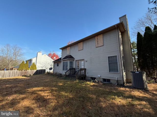 back of property with a yard and central AC unit