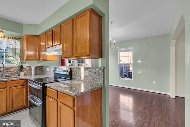 kitchen featuring sink, a chandelier, stone countertops, electric stove, and light wood-type flooring