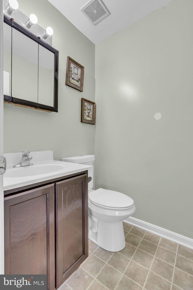 bathroom featuring tile patterned flooring, vanity, and toilet