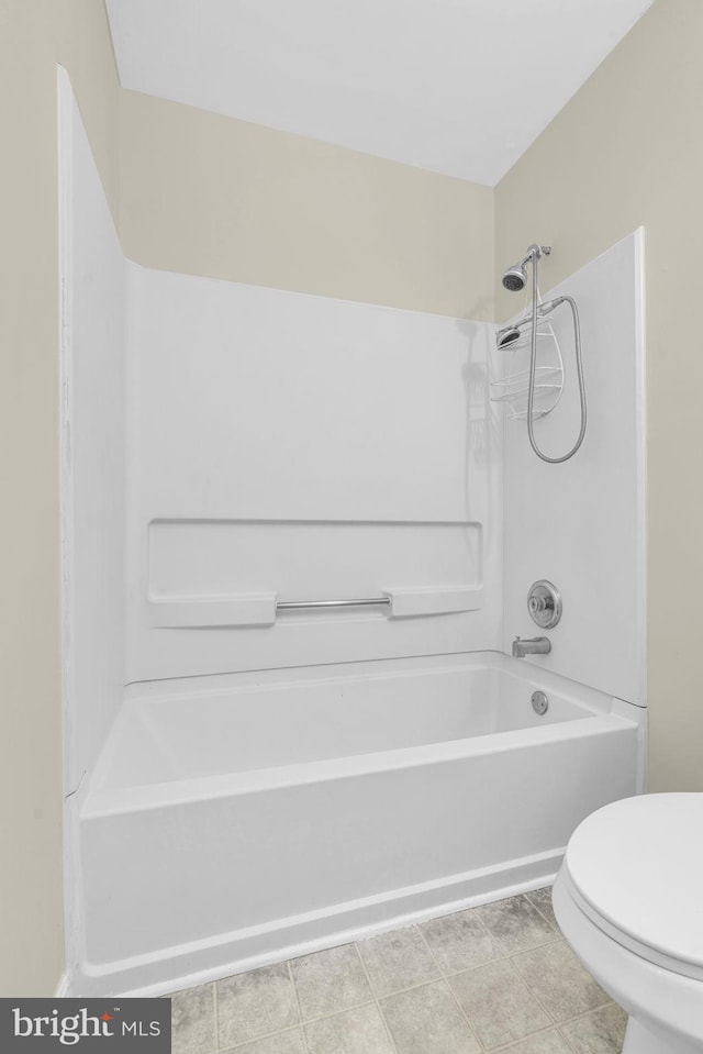 bathroom with tile patterned flooring, toilet, and shower / washtub combination