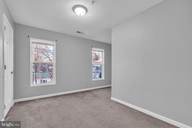 carpeted empty room featuring plenty of natural light