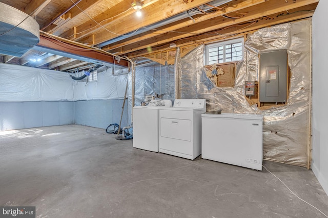 basement featuring washer and dryer, refrigerator, and electric panel