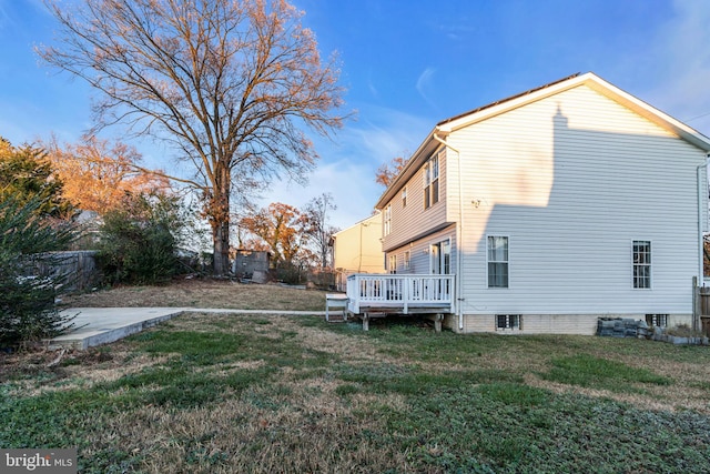 view of property exterior featuring a wooden deck and a yard