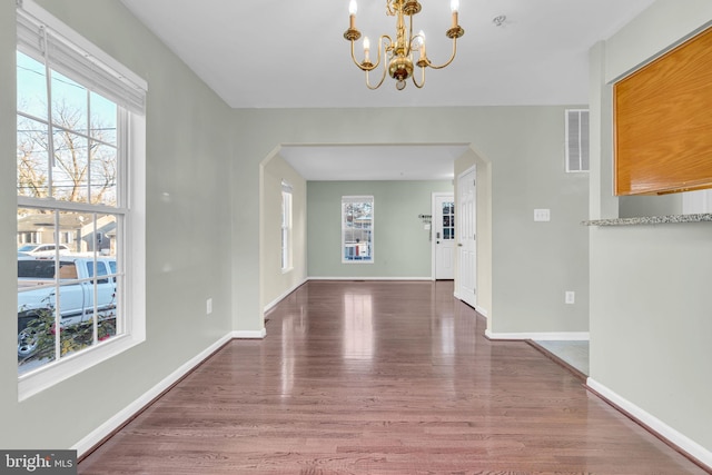 unfurnished dining area with dark hardwood / wood-style floors and plenty of natural light