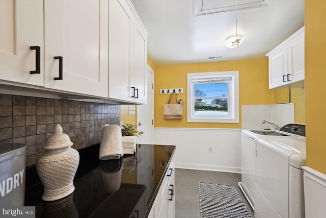 laundry area featuring independent washer and dryer and cabinets