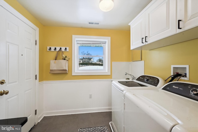 laundry room with washing machine and dryer and cabinets