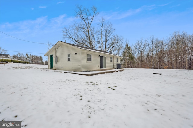 snow covered back of property with central air condition unit