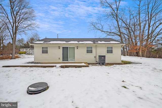 snow covered back of property with central AC unit