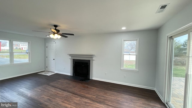 unfurnished living room with ceiling fan, plenty of natural light, and dark hardwood / wood-style floors