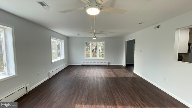 spare room with baseboard heating and dark wood-type flooring