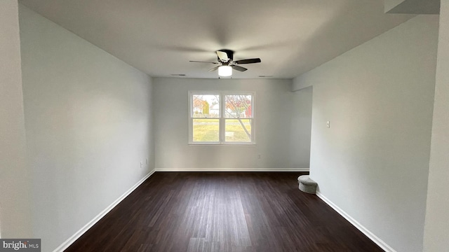 spare room featuring ceiling fan and dark wood-type flooring