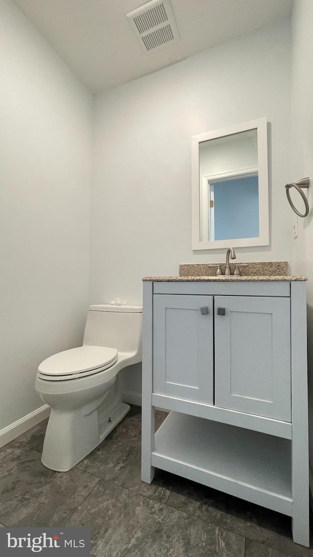 bathroom featuring vanity and toilet