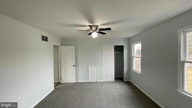 unfurnished bedroom featuring carpet floors, multiple windows, and ceiling fan